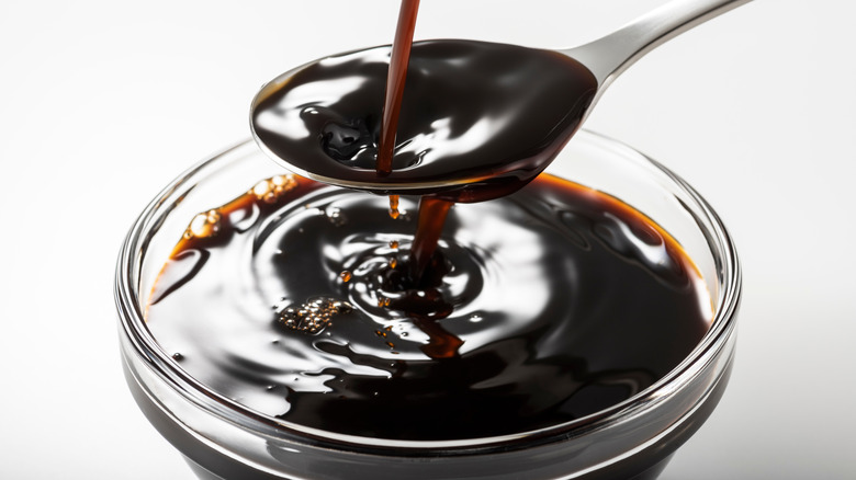 Worcestershire sauce pouring into a glass bowl