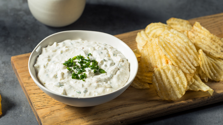 French onion dip and chips on wooden board