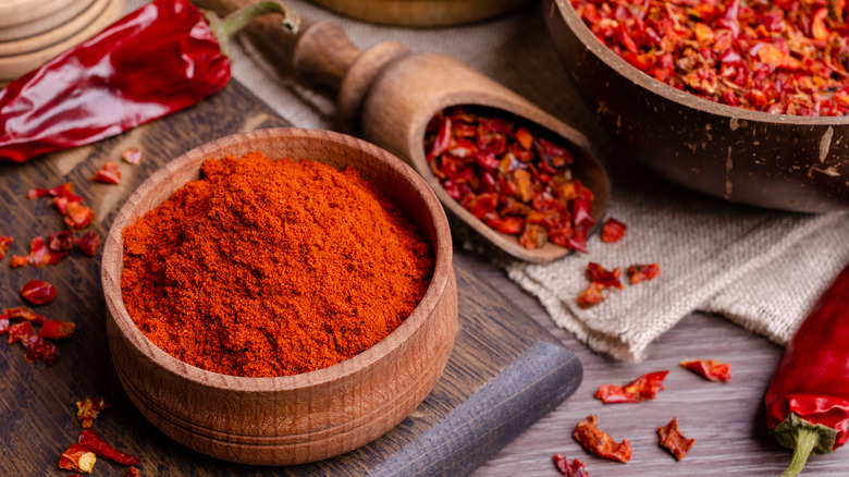 paprika in wood bowl with whole peppers