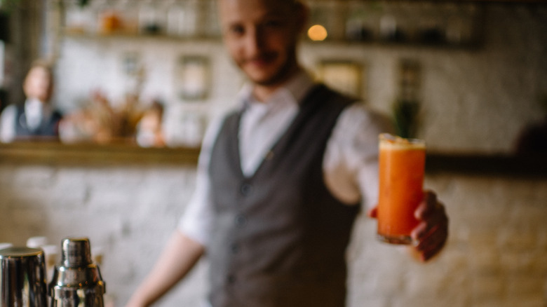 Server handing Garibaldi cocktail