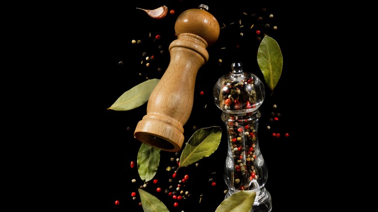 Two pepper grinders with spices