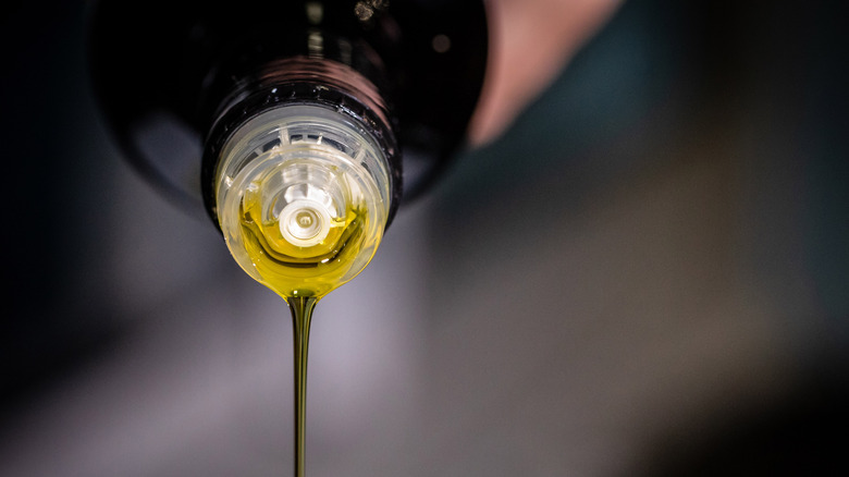 Olive oil pouring from bottle top