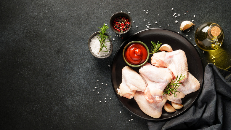 raw chicken wings with spices and oil