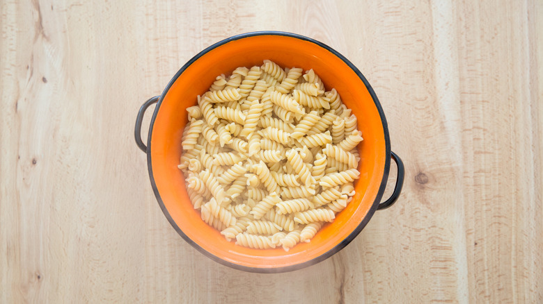 cooked pasta in orange colander