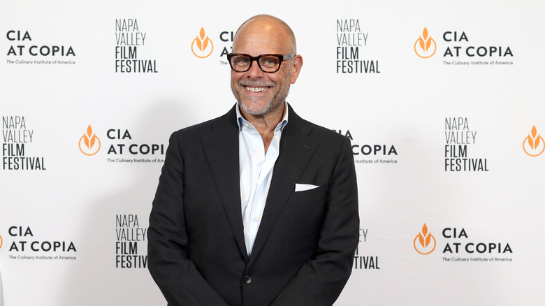 Alton Brown smiling at a press event