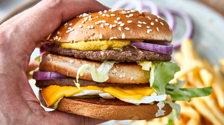 Double cheese burger in hand