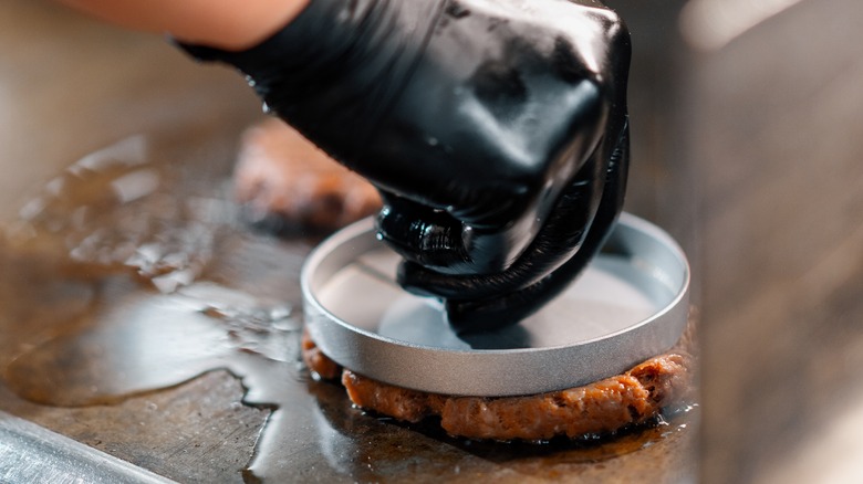 smash burger pressed onto griddle