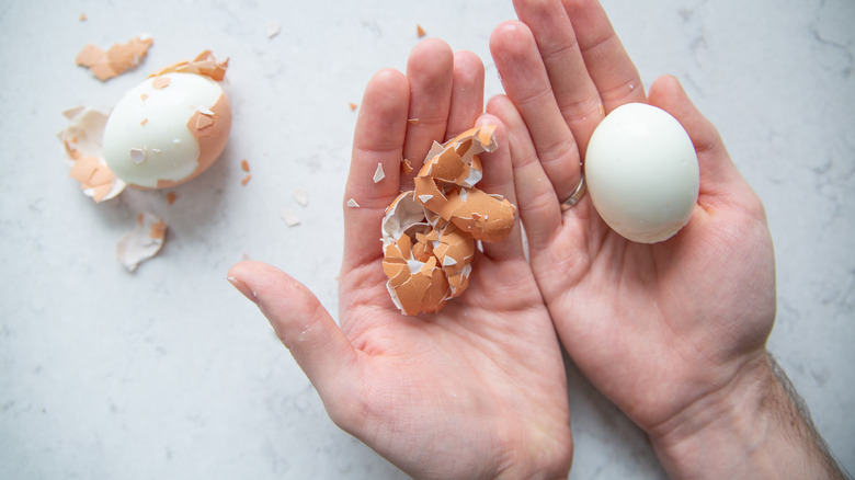 hands peeling hard-boiled eggs