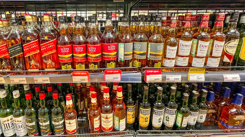 Shelf at liquor store showing many kinds of spirits