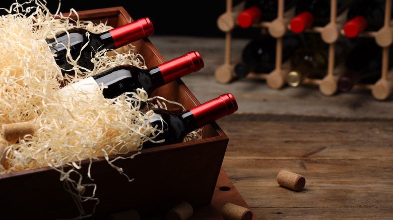 Open crate of wine bottles packed in shavings