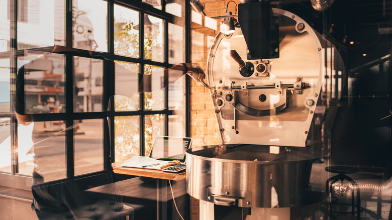 Modern coffee roaster in warehouse with laptop 