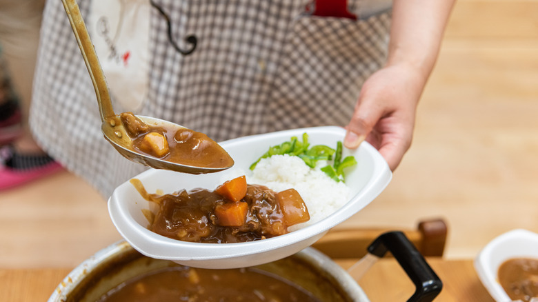 person serving curry rice