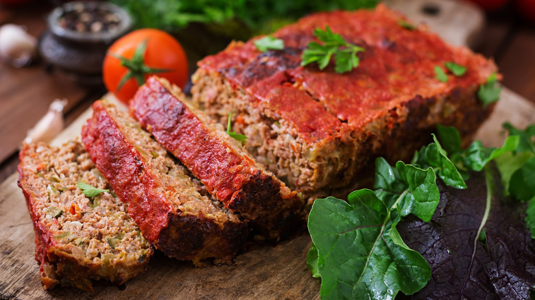 long meatloaf sliced with tomatoes