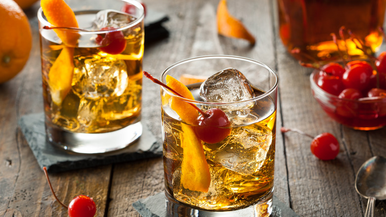 Old Fashioned cocktails with cherries and orange