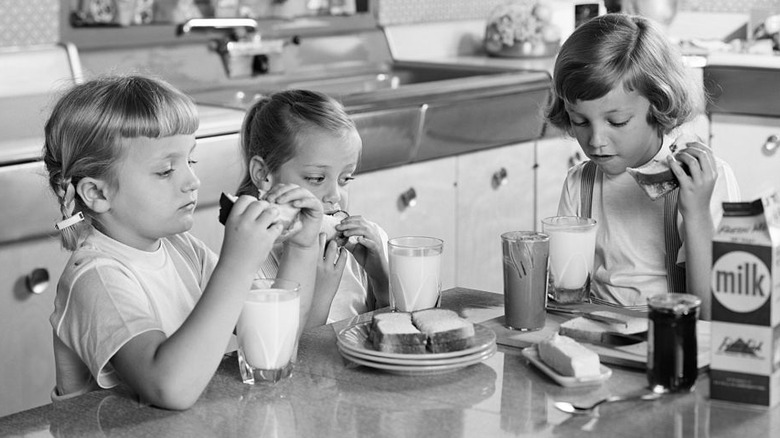 Kids eating peanut butter sandwiches