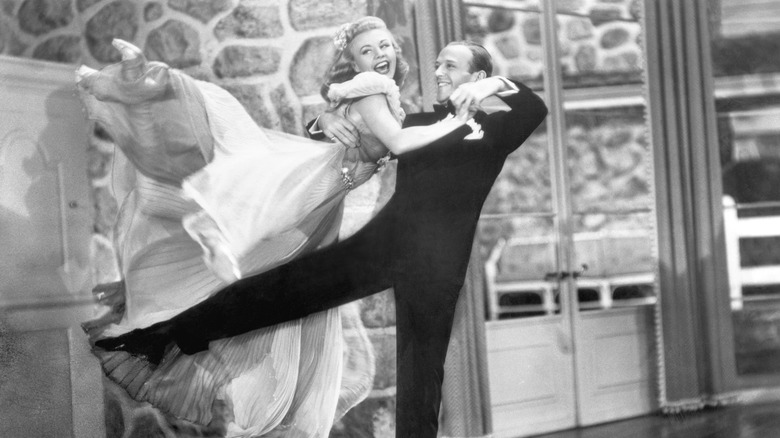 Ginger Rogers being twirled in a flowing dress by Fred Astaire