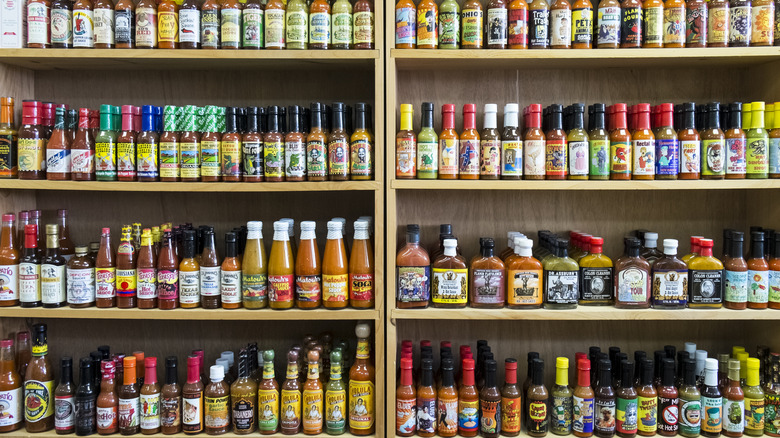 bottles of different hot sauces on shelves