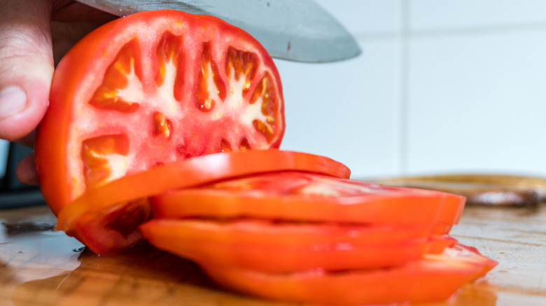 Knife cutting tomato 