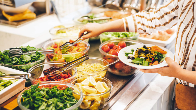 Person selecting food in a buffet line