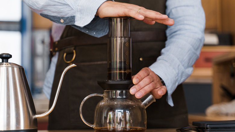 barista using AeroPress device