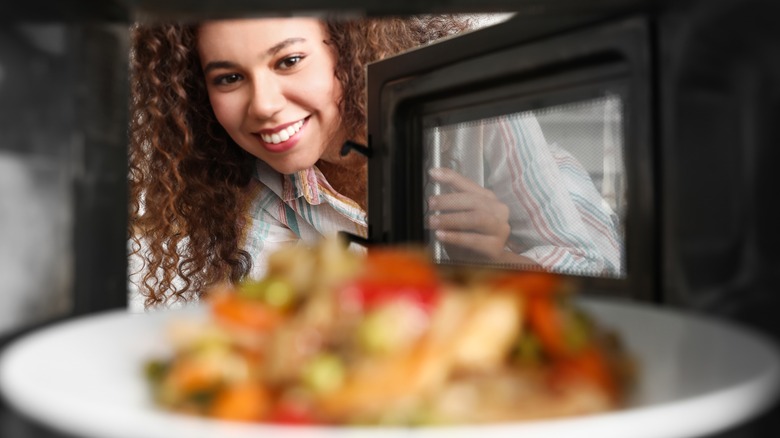 Woman microwaving a meal