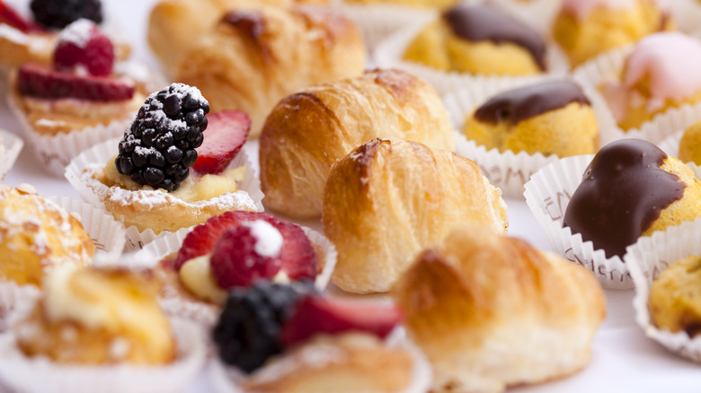 Rows of cream puffs, eclairs, and patisseries lined up