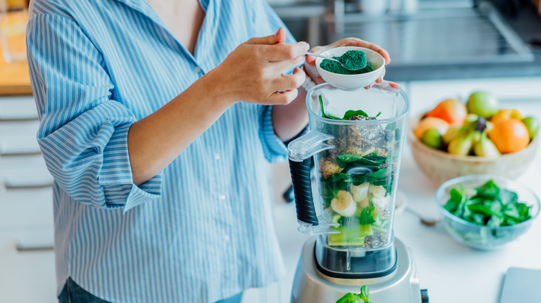 Woman preparing healthy vegan smoothie