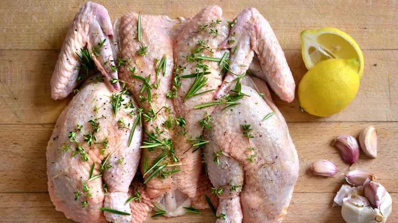 Spatchcocked raw whole chicken herbs lemon