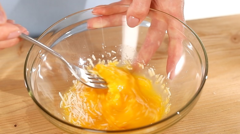 whisking egg in bowl with fork