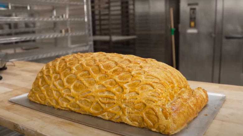 The cooked beef wellington on a tray in a kitchen