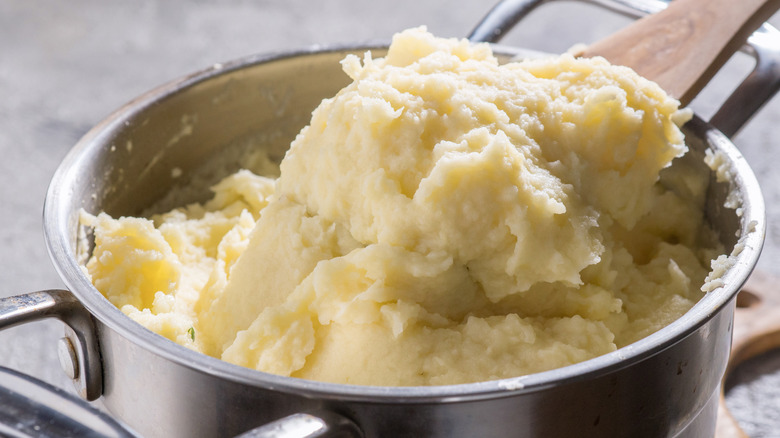 scooping mashed potatoes out of pot