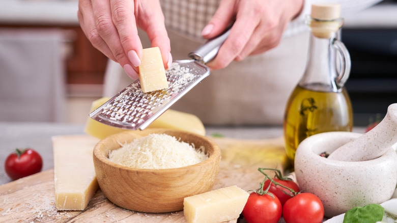 hands grating parmesan cheese