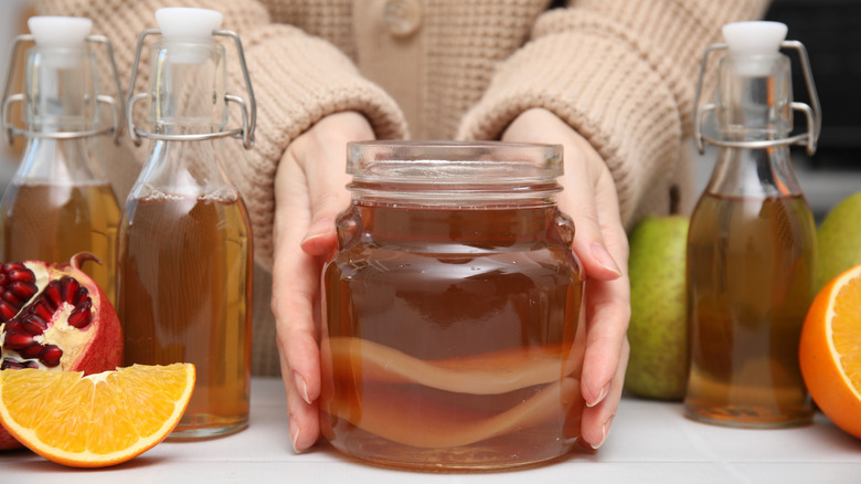 Homebrewer holding a jar of homemade kombucha