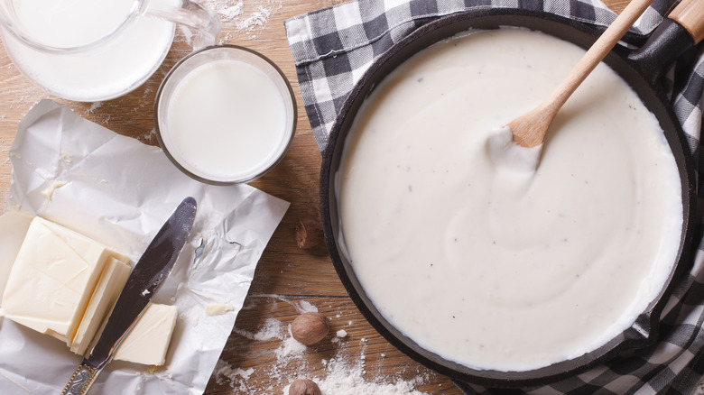 bechamel sauce in pan beside ingredients