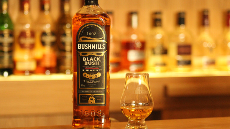 bottle of Bushmills Bush Black next to tasting glass