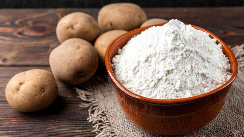 Bowl of potato starch with potatoes.