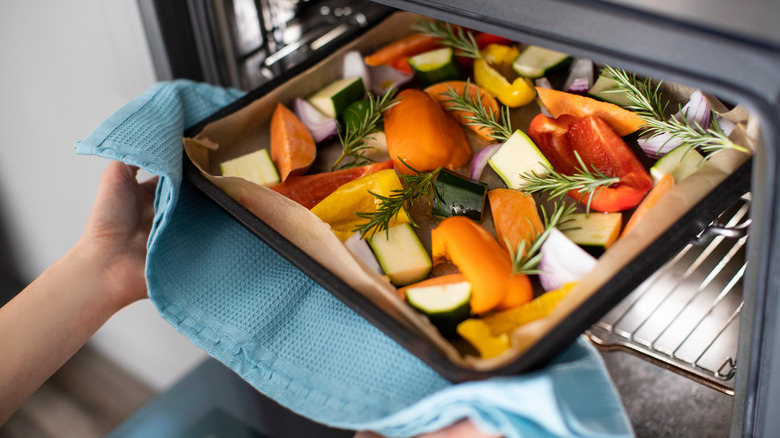 person taking vegetables out of oven