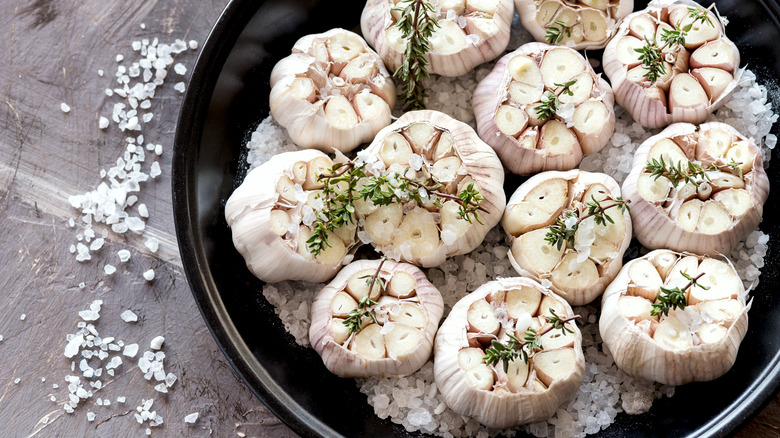 uncooked heads of garlic in black pot