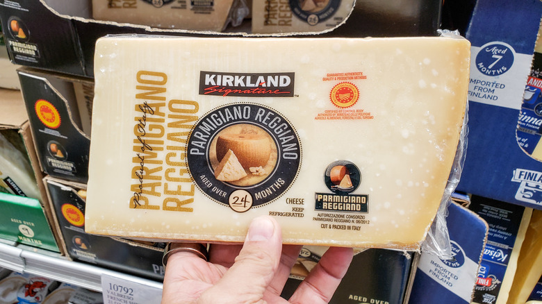 Hand holding Costco's Kirkland Parmigiano-Reggiano cheese