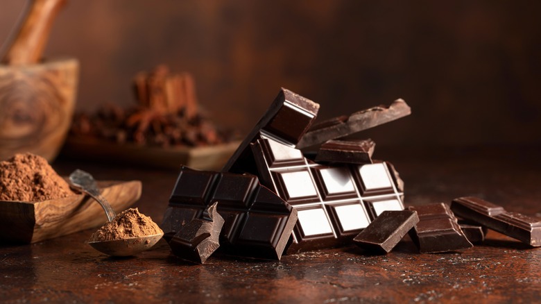 Cocoa powder and dark chocolate on brown table