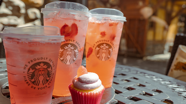 Three Starbucks refreshers with cupcake