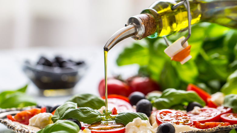 pouring oil over caprese salad