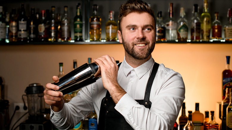 Bearded bartender holding cocktail shaker