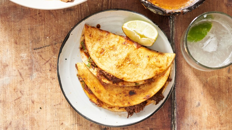 Birria quesadillas on a plate next to a margarita