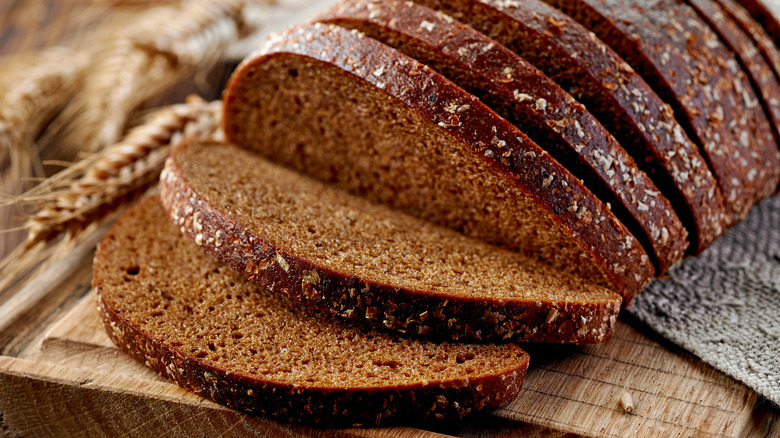 A oval loaf of rye bread sliced open on a cutting board