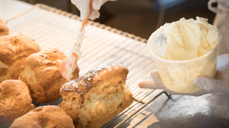 Buttering the tops of biscuits