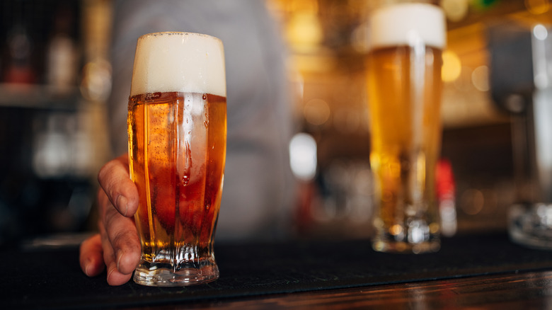 A bartender serving a light beer