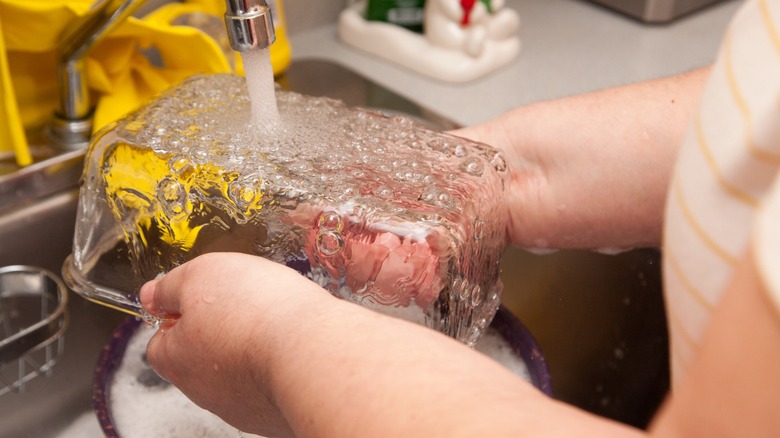 water runs over a glass dish in the sink