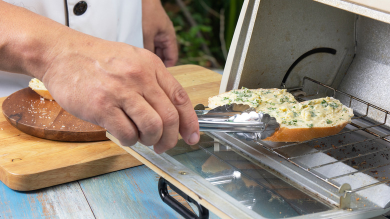 putting garlic bread in oven