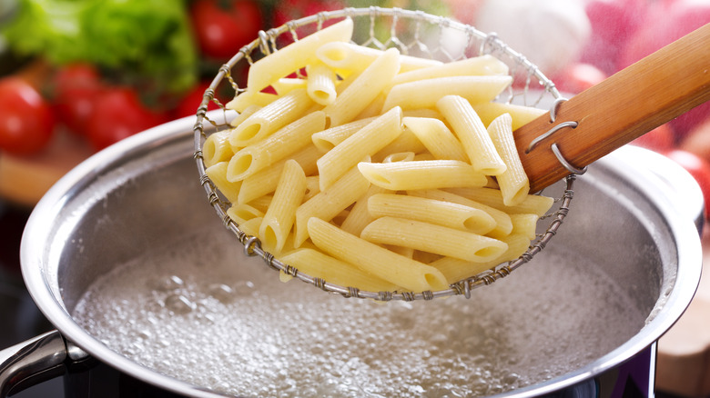 Cooked pasta in a spider strainer